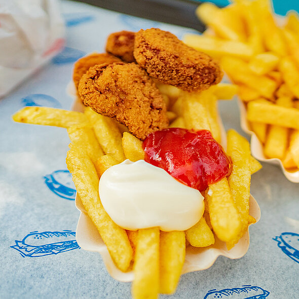 Pommes bunt mit leckeren Chicken Nuggets werden beim Geburtstag angeboten.
