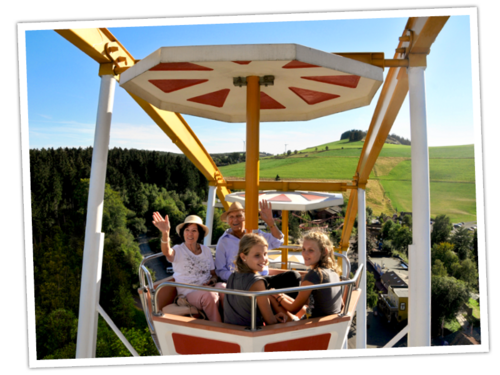 Oma und Opa genießen an einem Wochenende im September die Fahrt mit ihren Enkeln im Riesenrad.