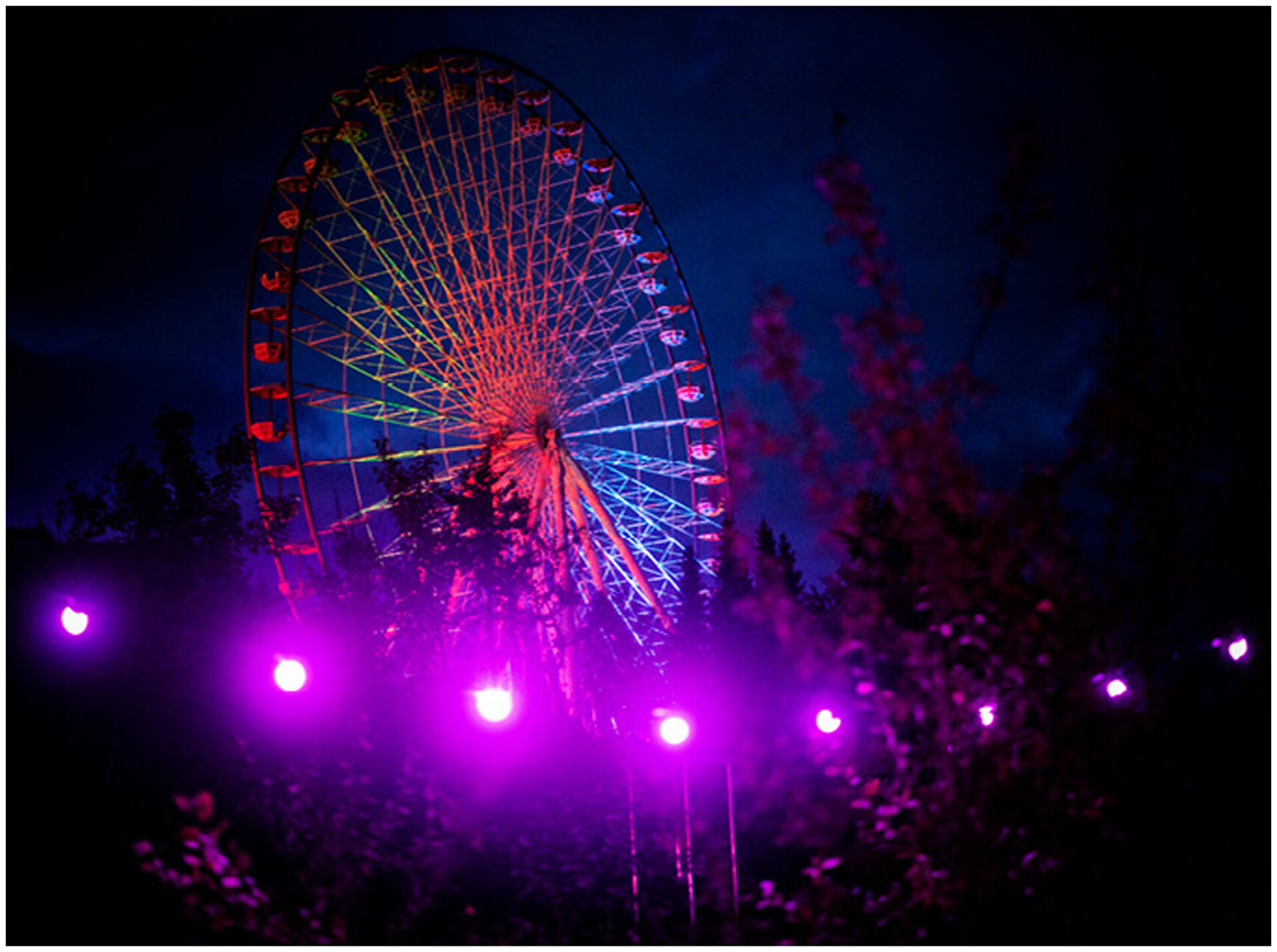 Riesenrad im Dunkeln wirkt mit seinen Lichteffekten sehr beeindruckend