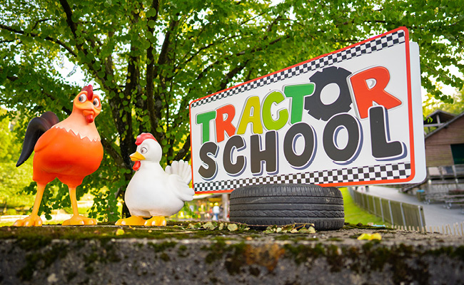 Das Tractor School Schild neben Huhn und Ente ist sehr schön anzusehen.