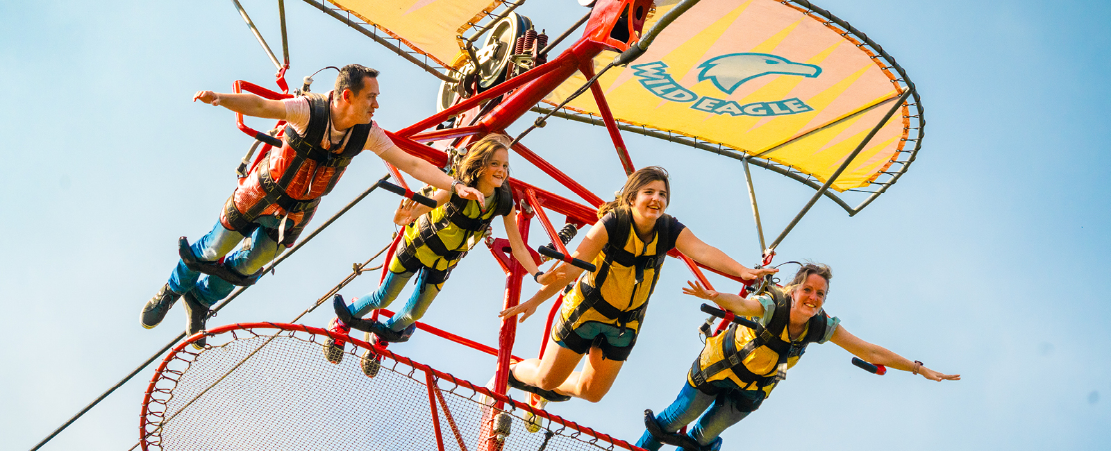 Im Drachenflieger mit 4 Personen fliegt die Familie über den Freizeitpark.