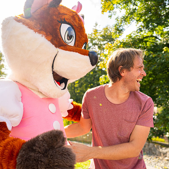 Der Papa vergnügt sich mit dem Maskottchen Frida im Park.