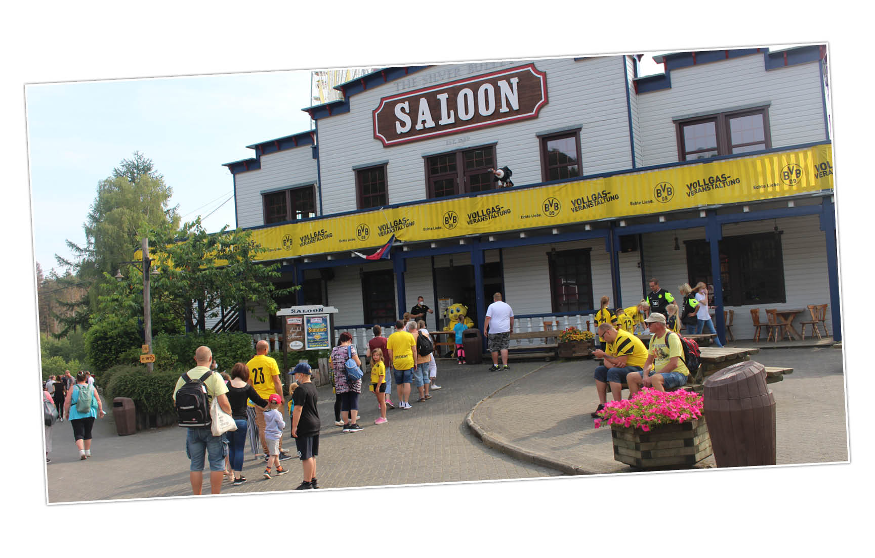 Die Gäste mit BVB-Trikots stehen vor dem Western-Saloon mit BVB-Bannern.