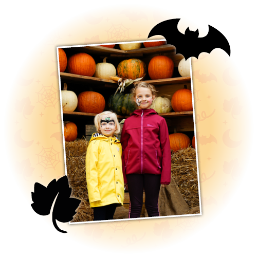 Die beiden Kids stehen vor dem Kürbis-Regal beim Event KidsOween.