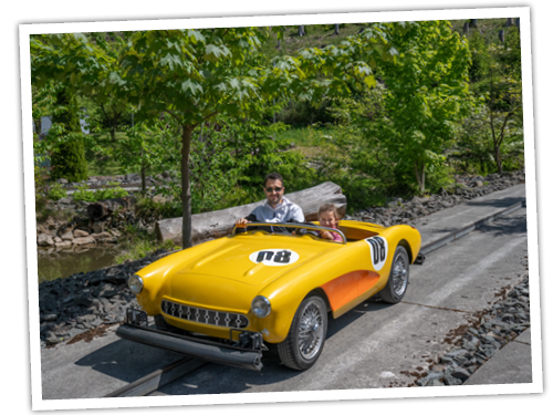 In einem gelben Auto der Rocky Mountain Rallye fährt ein Vater mit seiner Tochter.