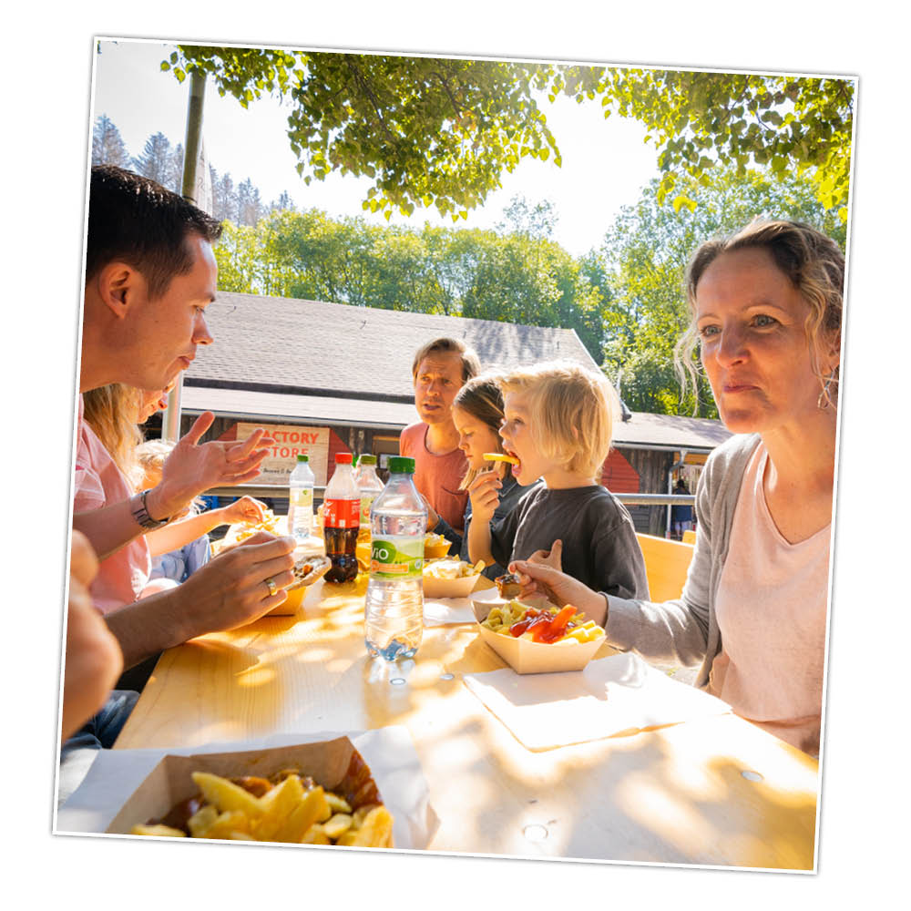 Die Familie macht bei leckeren Pommes Pause im Park.