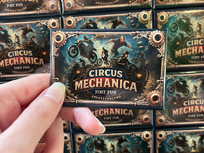 Merchandise von Circus Mechanica wird in einer Hand angeboten.