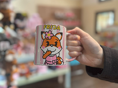 Eine Person hält die Tasse mit Frida fest in der Hand.