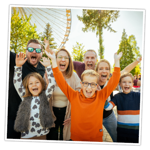 Zwei Familien freuen sich vorm Riesenrad, vielleicht über ihre tollen Gewinne.