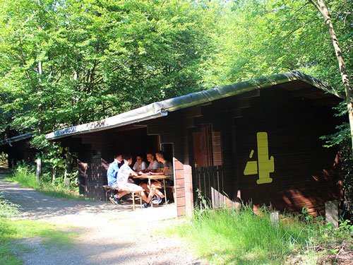 Die Jungs sitzen vor dem Blockhaus im Abenteuercamp und erzählen sich Geschichten.