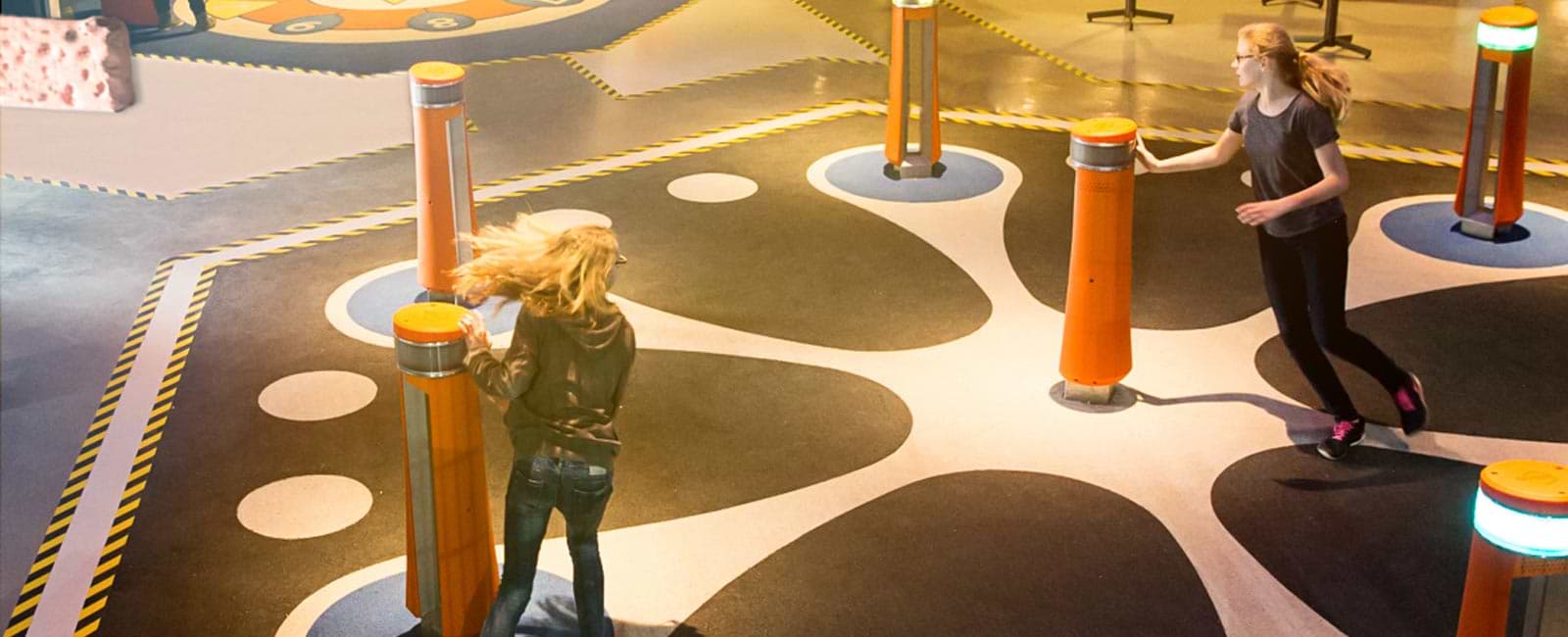 An verschiedenen Spielsäulen berühren die Kinder die Touch-Displays und spielen Memo.
